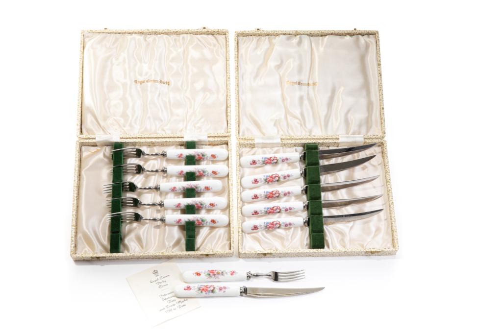 ROYAL CROWN DERBY CASED FORKS & KNIVES SET: English, white ground porcelain handled utensils with floral design. Two boxes with six forks and six knives, makers mark on the blade. L. of knife 21.75 cm (8 1/2 in) L. of fork 18 cm (7 in)