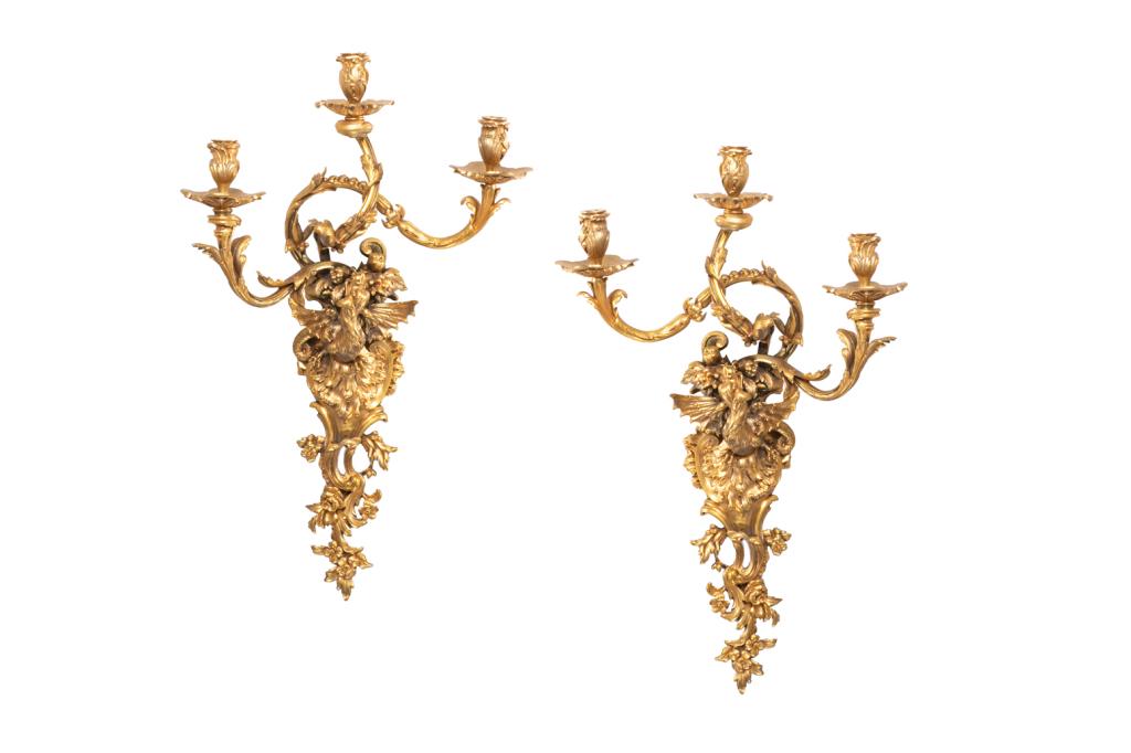 FINE PAIR OF BRONZE GILT THREE BRANCH WALL SCONCES: Ormolu cast sconce with ornate figural dragon beneath a fruit and floral cornucopia bouquet and a foliate motif base. Dragons face each other when hung. Not converted to electricity. French, late 19th