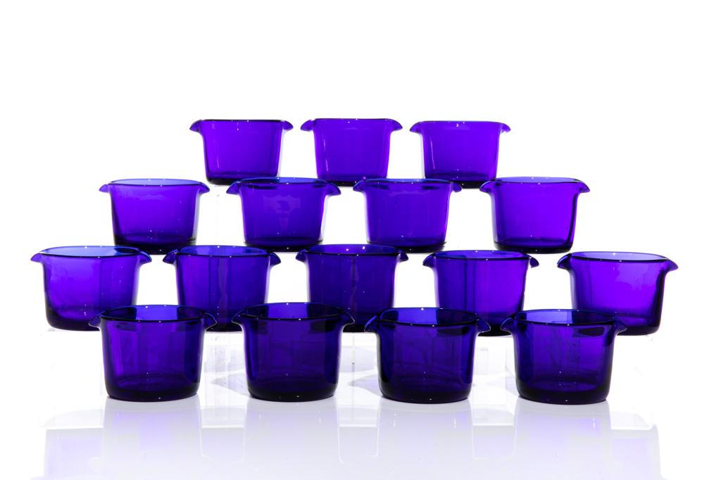 SEVENTEEN GEORGE III COBALT GLASS WINE RINSERS: English, early 19th century (c.1810) Bristol blue glass rinsers, each with opposing flared spouts or double lipped. H. of each 8.5 cm (3 3/8 in) W. from spout to spout 13.5 cm Provenance: The Estate o