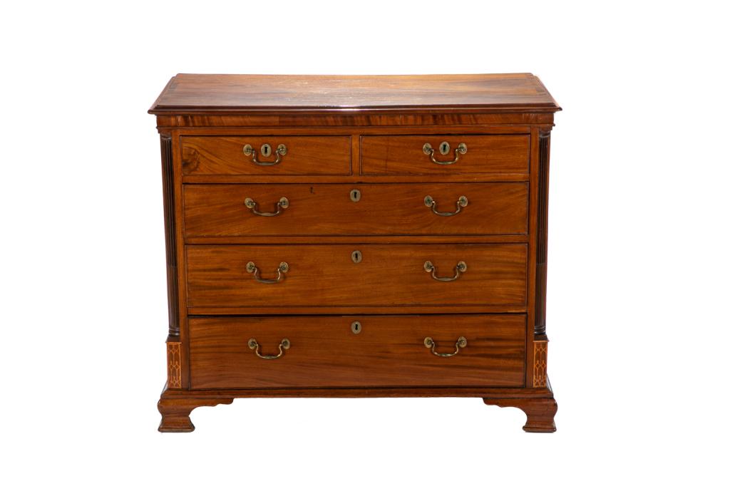 GEORGE III MAHOGANY FIVE DRAWER CHEST: Lightly coloured and highly figured mahogany bureau on a curved bracket foot with decorative quarter column corners sitting on an inlaid plinth. One drawer opens to reveal a writing slide inset in gre