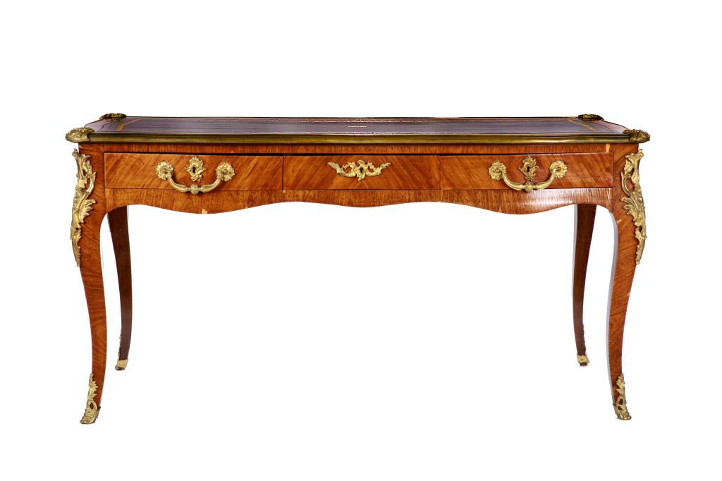 LOUIS XV STYLE BUREAU PLAT WITH ORMOLU MOUNTS: Mahogany desk. Serpentine front, cabriole legs with bronze gilt trim, mounts and sabots. Top surface inset with black tooled leather and gilt trim. three drawers to front, matching faux drawers to rev