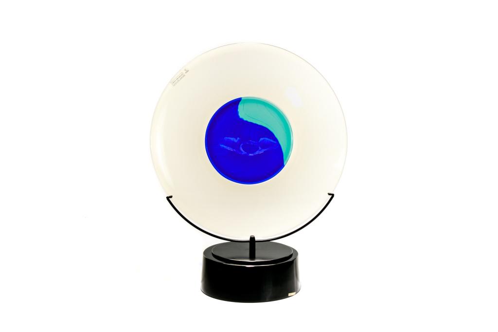 LINO TAGLIAPIETRA (Italian, b. 1934): Murano Incalmo glass charger plate with stand, for Effetre International. Etched with artist name on the backside of charger, dated 1988. Clear glass with central blue and turquoise disk. Dia. of char