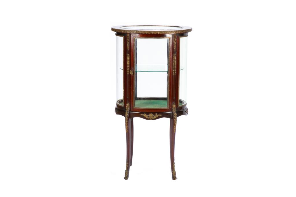 SMALL FRENCH CIRCULAR VITRINE CABINET: French two-tier oval rosewood curio cabinet with ormolu mounts on four serpentine legs. French, late 19th c. H. 39 3/4" W. 21 1/4" D.15 1/4"