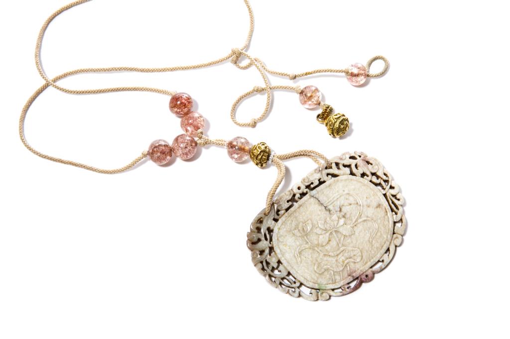 CHINESE CHICKEN BONE JADE PLAQUE PENDANT: Carved on one side with calligraphy inscription, and on the reverse with lotus flowers. Framed by a openwork carved double dragon and floral border. Attached with beaded string as a pendant. Jade Ming