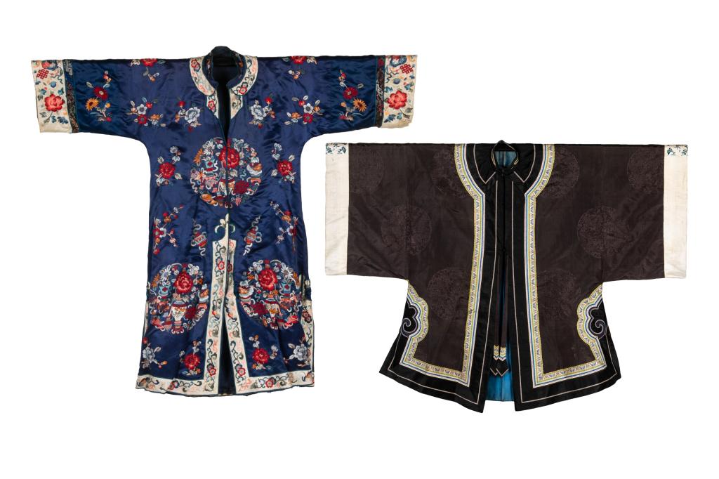 TWO CHINESE SILK EMBROIDERED LADY'S ROBE: One of a aubergine ground with decorations of dragon roundels, and silk fringe borders. The other of a blue ground robe embroidered with flowers and auspicious emblem roundels. Larger shoulder length:
