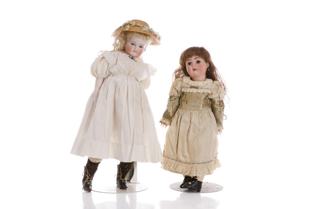 TWO ANTIQUE ALT, BECK & GOTTSCHALK BISQUE DOLLS: Both female dolls. Larger with bisque shoulder head and arms. Kid leather body. Fixed blue glass eyes with painted lashes and brows. Attached blonde mohair ringlets. Wearing period clothing including 