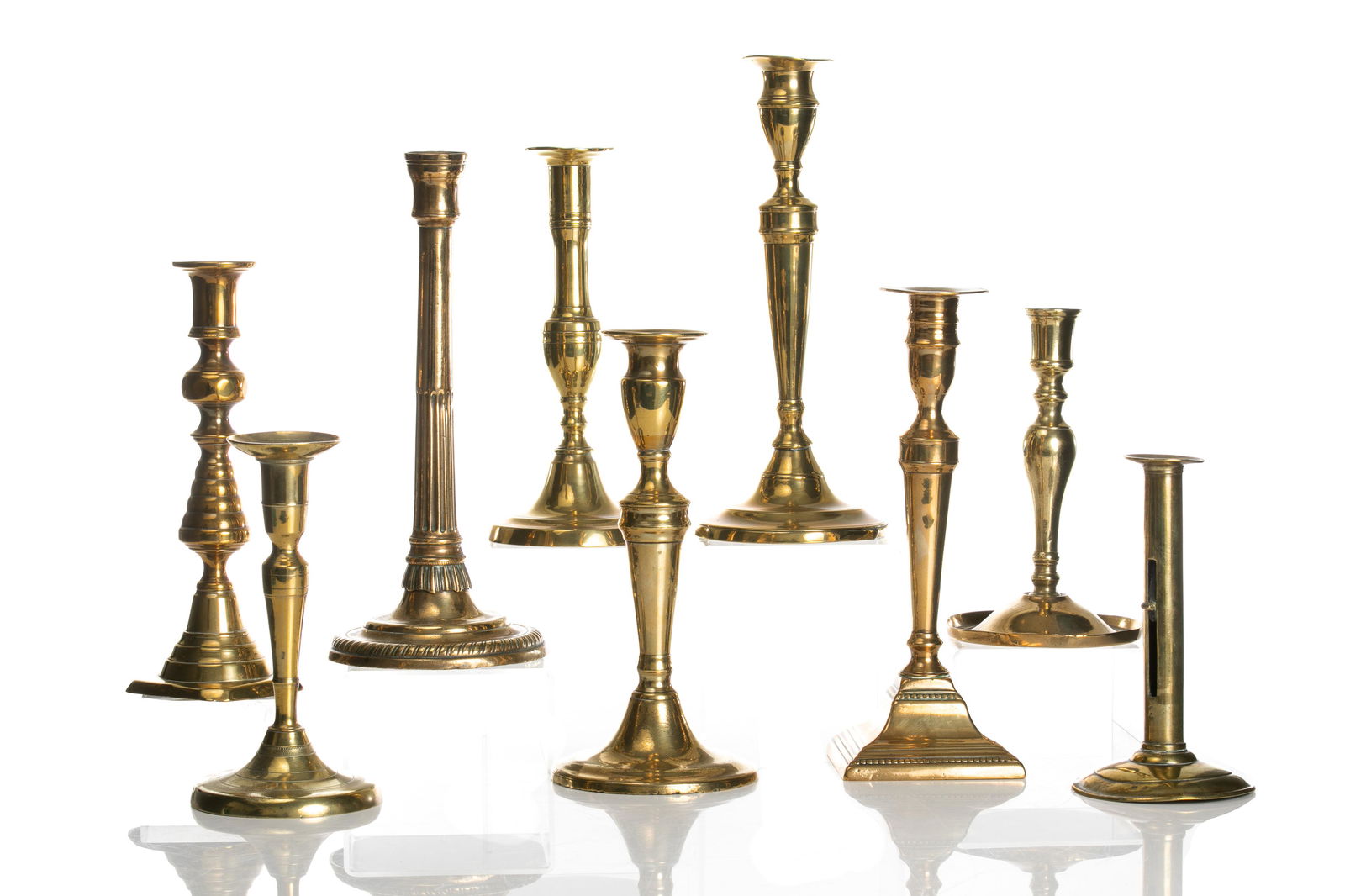 NINE GEORGIAN BRASS CANDLESTICKS (1 of 2)