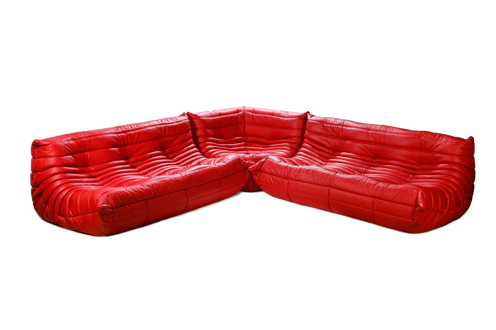 RED LEATHER LIGNE ROSET TOGO MODULAR SOFA SET: Including two sofas and a corner chair fits together as a modular sectional sofa. For Roche Bobois, Made in France, designed by Michel Ducaroy. Love seat sectionals each: H. 27" W. 67" D. 39" Corner s
