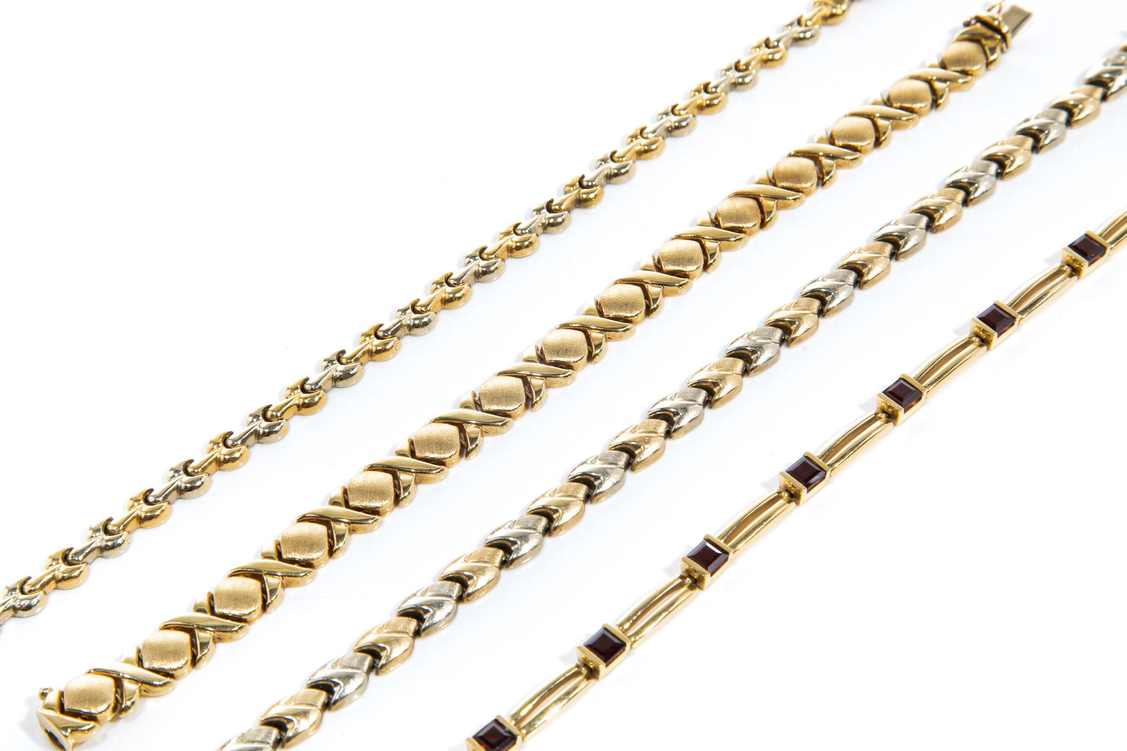 FOUR GOLD LINK BRACELETS, 52g: One with alternating yellow gold circles and crosses; one with alternating yellow and white gold woven motif links; one with alternating yellow and white gold links; and one with gold links alternatin
