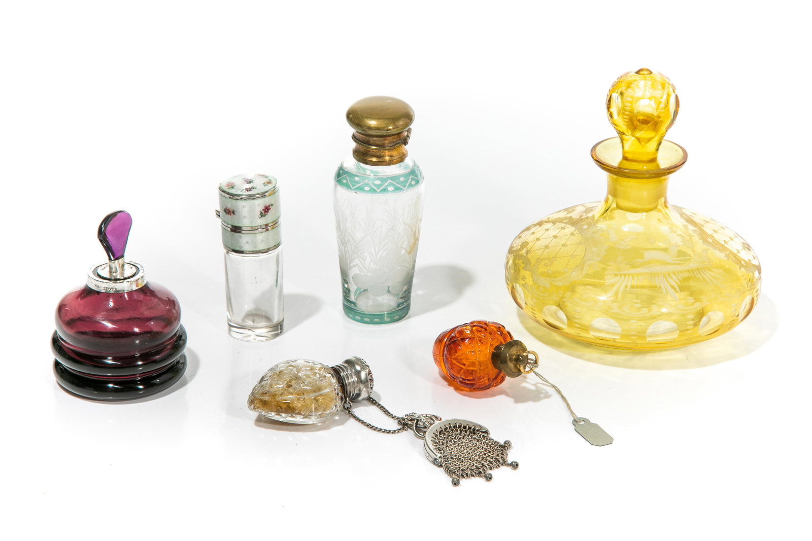 SIX VINTAGE GLASS SCENT BOTTLES: Including one lemon glass bottle with etched design; one amethyst shaped bottle with silver lid and amethyst glass finial; one clear glass bottle with etched and coloured design and metal hinged top w