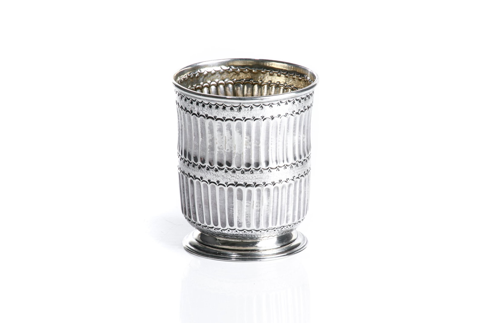 EARLY STYLE ENGLISH SILVER BEAKER, 152g: Fluted beaker in a late 17th C style on a cast foot. The bottom embellished with a period Queen Anne coin. H. 8.6 cm (3 3/8 in.)