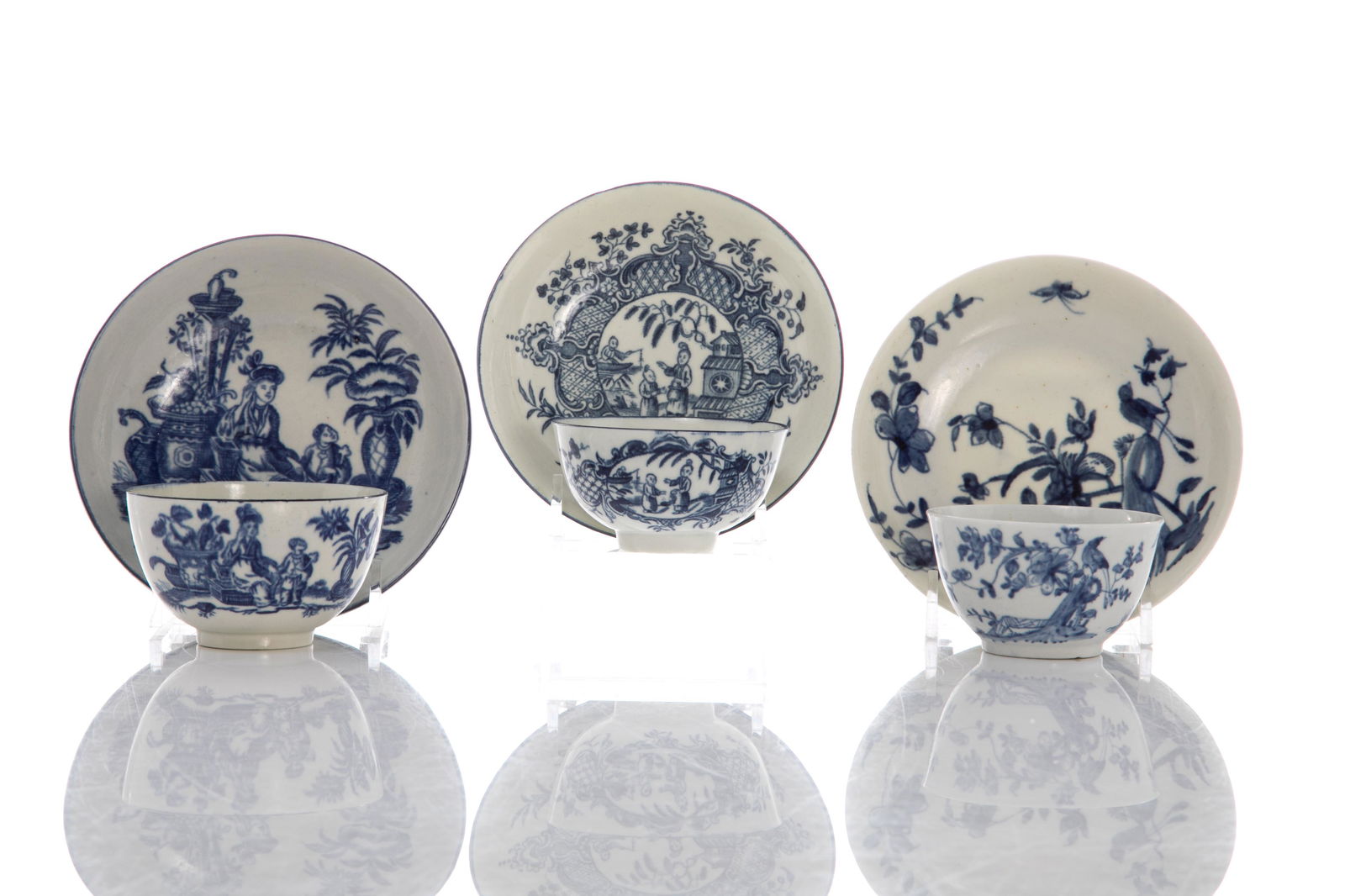 THREE 18TH C PORCELAIN TEA BOWLS AND SAUCERS: English, late 18th C. blue & white porcelain. Each with various floral and Chinoiserie domestic scenes. One cup and saucer plus additional saucer with crescent moon marks to the underside, one cup wit