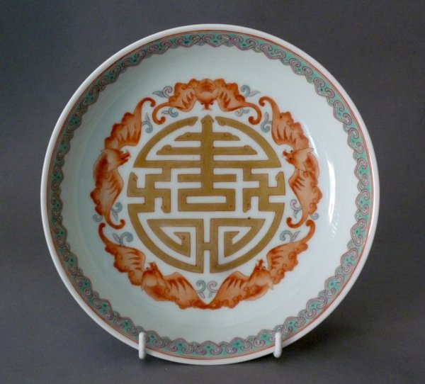 CHINESE FAMILLE ROSE PORCELAIN DISH: Chinese famille rose porcelain circular dish painted with five iron red bats around a large central stylized character in gold. Lappet turquoise and puce border. The exterior rim painted with various 