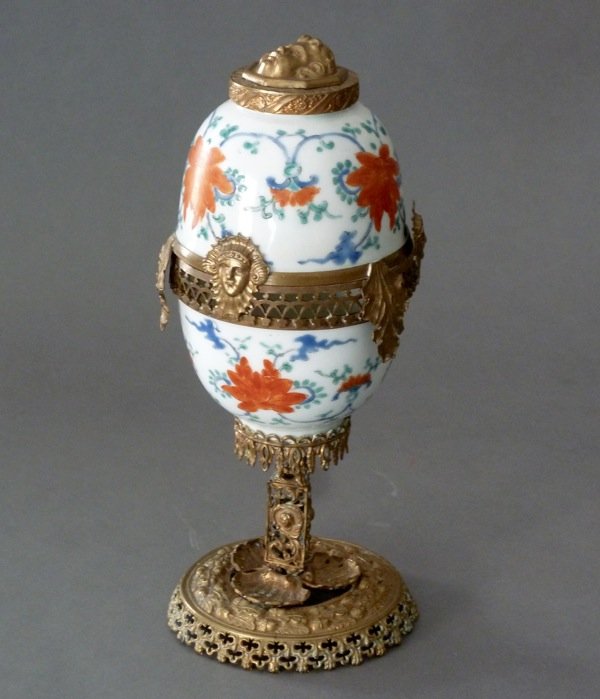 PAIR OF CHINESE PORCELAIN TEA BOWLS, MOUNTED: Pair of Chinese porcelain tea bowls with red, green and blue enamel. Both mounted with metal as an egg on stand. China, 19th century. Diameter of cups 6.5 cm (2 1/2 in).