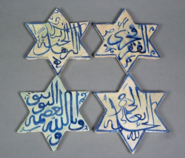PERSIAN SAFAVID BLUE AND WHITE POTTERY STAR TILES: Four Safavid underglaze blue pottery star tiles. Each decorated with caligraphy, three with a painted border. W 16.5 - 17 cm (6 1/2 - 6 3/4 in). Persia, possibly 16th Century. All restored.