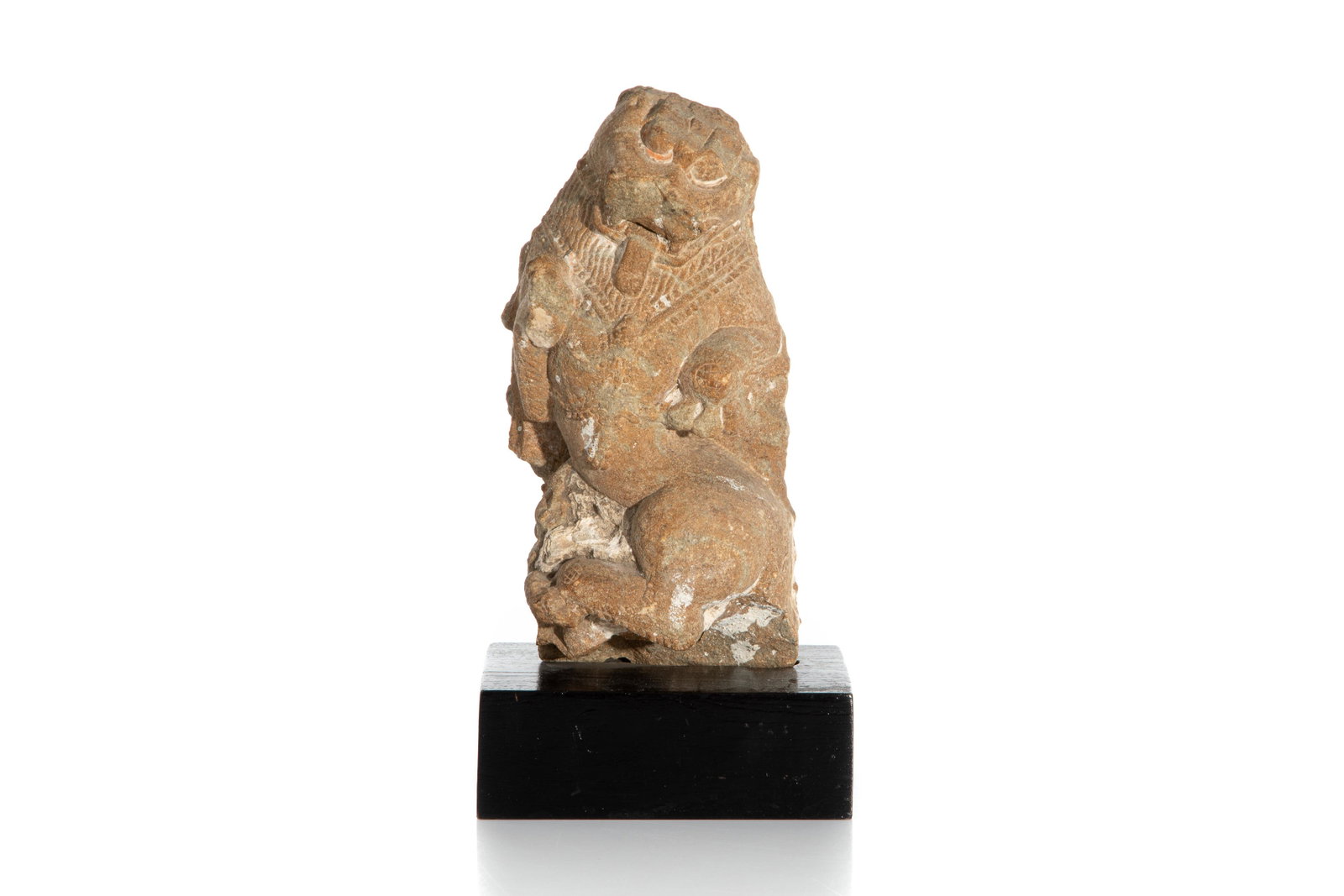 INDIAN SANDSTONE LION: 12th century, dancing stone lion with prominent tongue sticking out, curvaceous body, traces of red and white paint. On wood stand, label on base of stand refers to an 1967 Estate in New Delhi. H. 21.