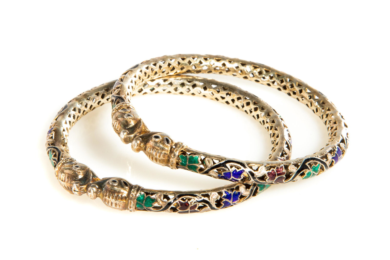 PAIR OF MUGHAL STYLE ENAMEL SILVER SERPENT BANGELS: An overall pierced foliate design. Weight: 31g t.w. Dia. 8cm (3 1/8in) Provenance: Held privately in an important West Coast collection, Victoria, B.C.