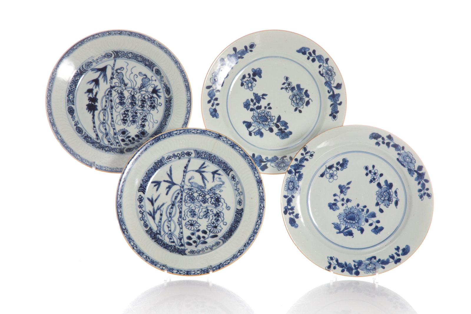 FOUR BLUE AND WHITE PLATES W/ SQUIRREL AND GRAPES: Chinese, Qing dynasty, two with pale blue bodies with floral sprigs on rim and centre; together with two decorated in underglaze blue featuring squirrels and grape clusters (symbolic of fertility) wit