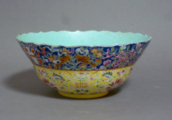 CHINESE FAMILLE ROSE ENAMEL BOWL WITH TURQUOISE: Chinese Famille rose bowl with turquoise interior and lotus shape rim. The exterior decorated on blue and yellow ground bands with lowers, objects and bats. Qianlong seal mark in red. W 17.8 cm (7"). 