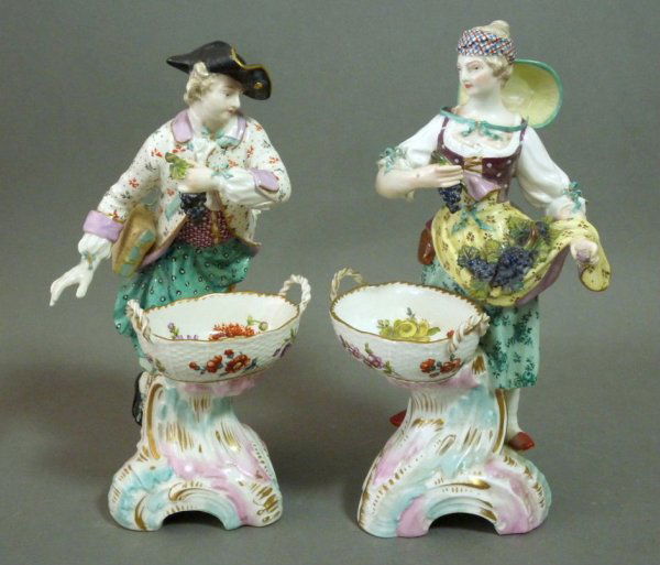PAIR OF KPM BERLIN PORCELAIN FIGURAL SWEETMEATS: Pair of KPM Berlin hand painted porcelain figural sweetmeats picking grapes into their baskets, late 19th century (minor loss and restoration.). H 23 cm. (9 in.)