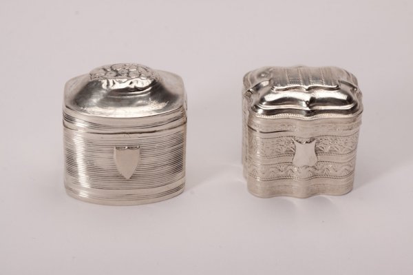 DUTCH SILVER SNUFF BOXES: Both rectangular, one with horizontal lines, a crest cartouche and a floral domed lid. The other lobed with bands of flowers and decoration. Dated 1852 and 1850 respectively. H 4 cm (1 1/2 in.)