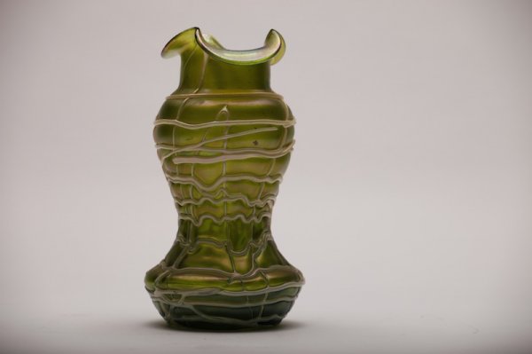 LOETZ STYLE GLASS VASE: Iridescent green body with scalloped rim with overall white threading. H 17.5 cm. (6 7/8 in.)
