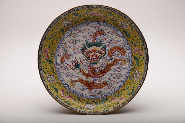 FINE QIANLONG CANTON ENAMEL DRAGON DISH: Painted with a dragon at center on a white field with clouds. A yellow floral border decorated with five red bats. The outside rim painted with dragons on a yellow field. A phoenox medallion in blue a