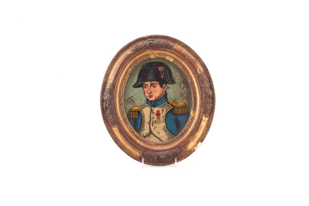 REVERSE PAINTING ON GLASS OF NAPOLEON BONAPARTE: Portrait of Napoleon in military uniform. In oval gilt frame decorated with floral bouquets. H. of frame: 26.7 cm (10 1/2 in)