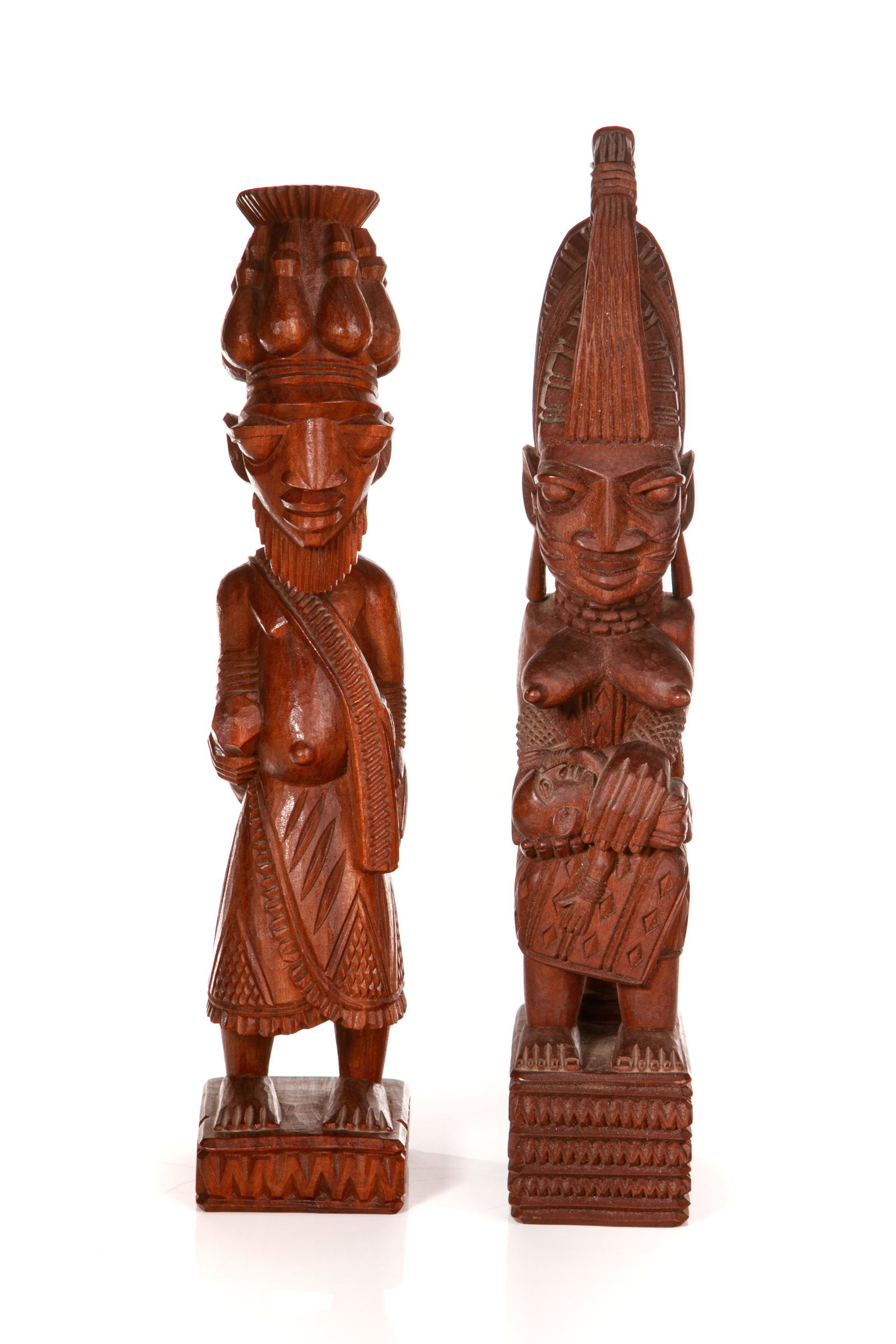 AKIN FAKEYE (Nigeria, 1936 - ): Two carved mahogany Yoruba sculptures by Nigerian artist Akin Fakeye. One is a depiction of a seated mother and her children, together with a standing male figure. Both with elaborate carvings, geomet