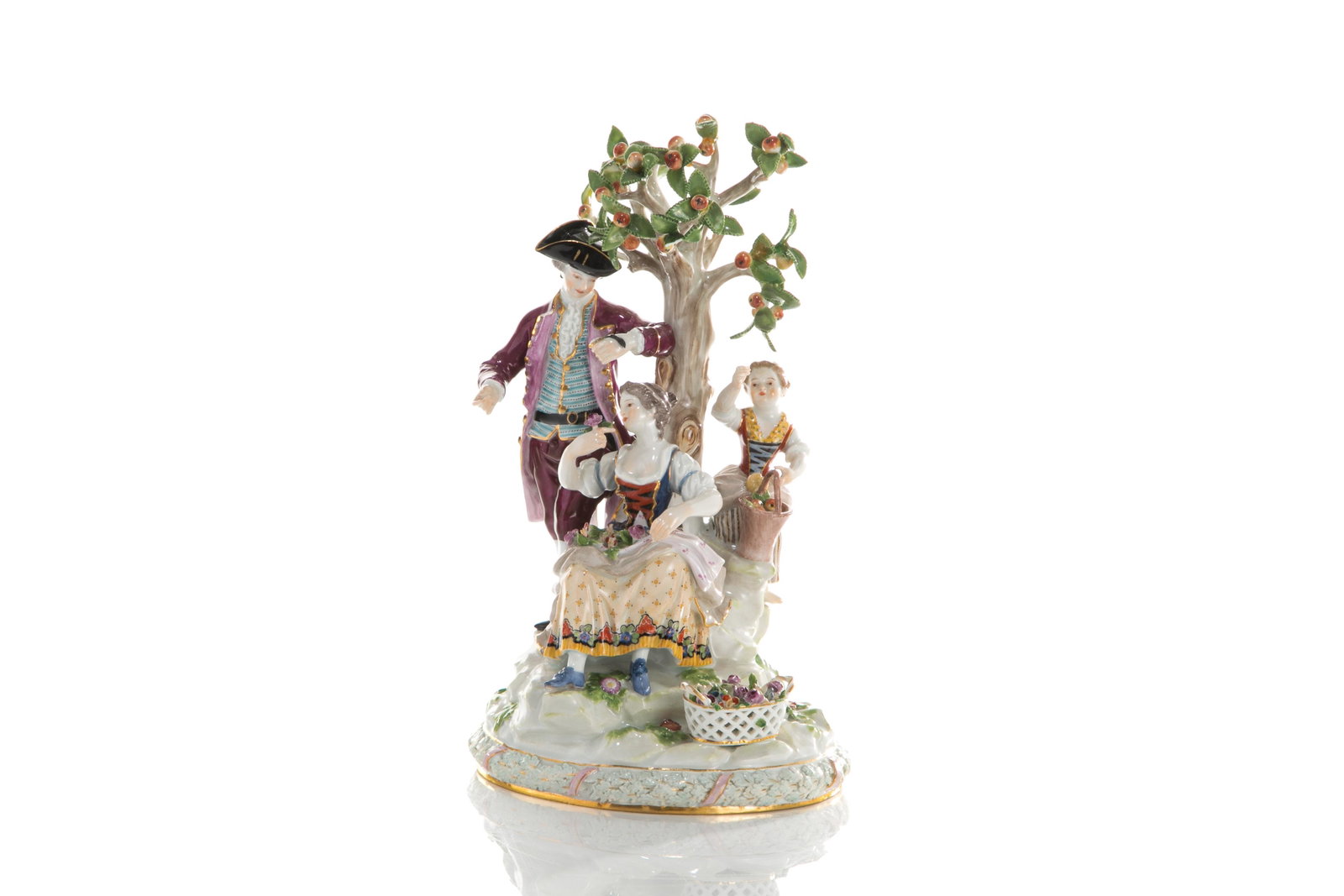 MEISSEN PORCELAIN FIGURAL GROUP: A trio of figures harvesting fruit and flowers beneath a tree. Crossed sword marks and impressed D94 to base. H. 26cm (10in)