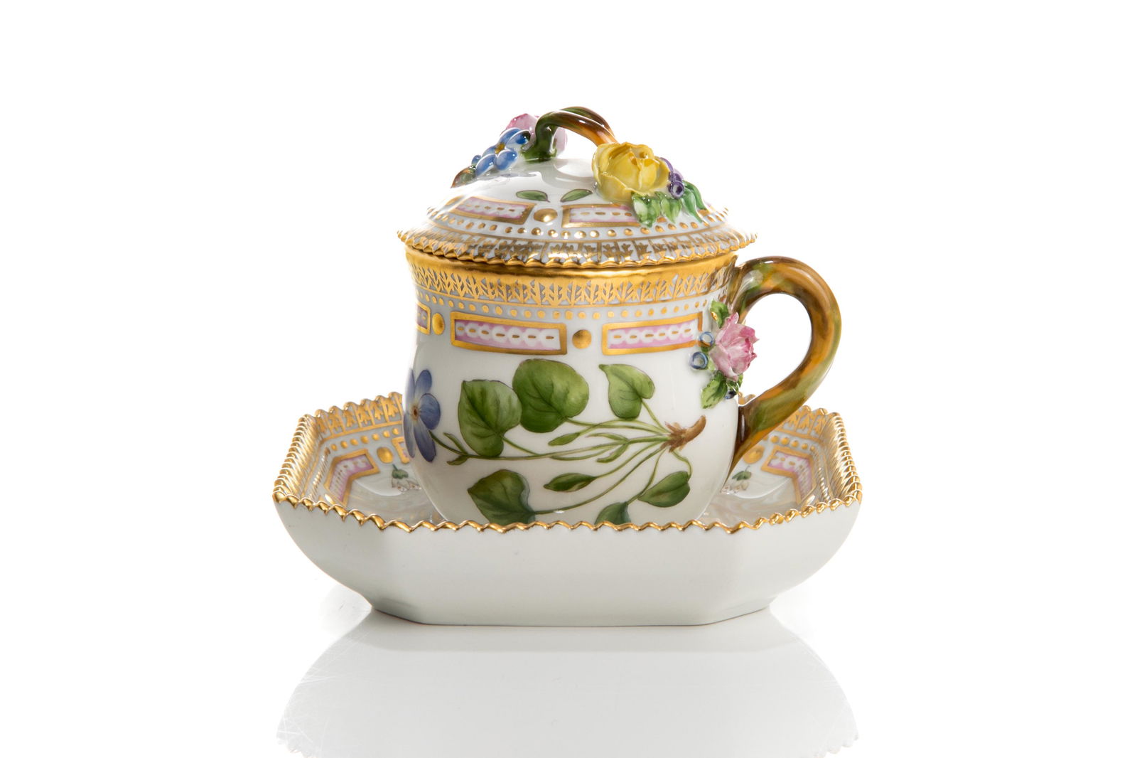 ROYAL COPENHAGEN FLORA DANICA PATTERN COVERED CUP: Copenhagen, Denmark, 1960s. A white ground porcelain covered cup and squared custard saucer, with hand painted floral details and gilded accents in "Flora Danica" pattern. Applied porcelain flower bud