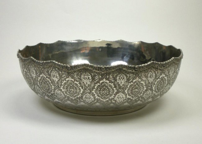 LARGE PERSIAN SILVER BASIN: Large circular bowl with shallow scalloped border and applied floral rim. The outside decorated with profuse engraving of foliage and birds. Marked to base, Iranian mid 20th century. D 33.5 cm. 1278 g