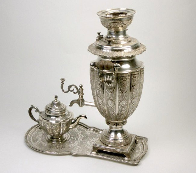 PERSIAN SILVER TEA URN WITH TRAY AND POT: With lobed body and profusely engraved floral detail too urn, tray and teapot. Appears complete. All pieces fully marked, Iranian early 20th century. Height of urn only , 38 cm. Total weight 3075 gram
