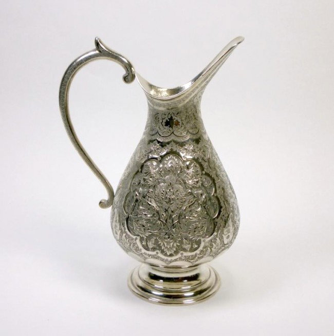 PERSIAN SILVER JUG: Of pear form with long spout and curved handle. Heavily engraved body with fine detailed decoration of birds flowers and foliage. Iranian, Early 20th century. H 24.8 cm. 673 grams.