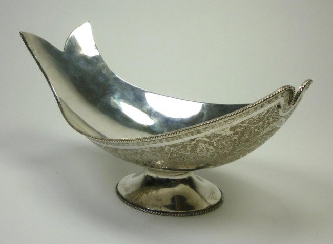 PERSIAN SILVER FISH FORM DISH: Footed bowl with a fish form border. The underside of the body with finely engraved decocration of birds and flowers. Marked to base, Iranian, 20th century. L 25.6 cm. 408 grams.