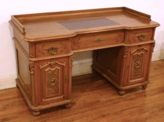 CARVED WALNUT 19th C. KNEE HOLE DESK : Late 19th century walnut carved knee hole desk on turned legs. Leather inset panel on top - wood gallery to back and sides. Three carved drawers and two carved doors. Brass pulls and escutcheons. Thre