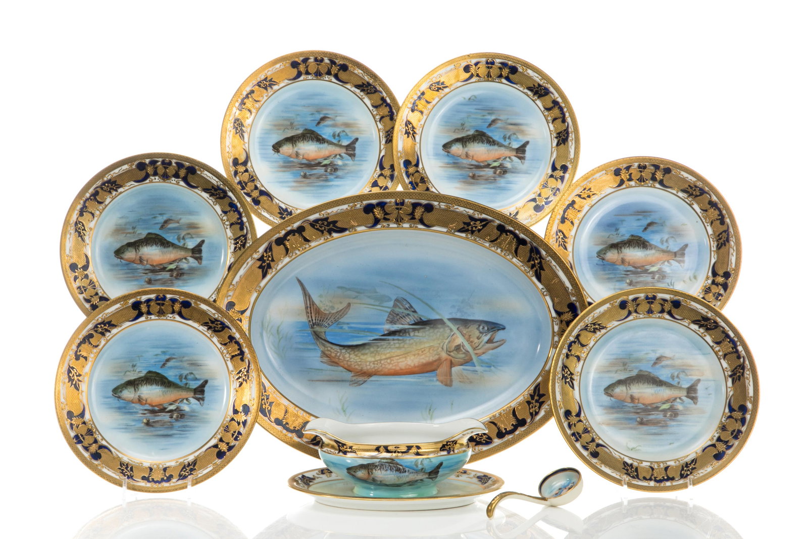 EIGHT NIPPON PORCELAIN FISH SERVICE: A group of eight of hand-painted Nippon porcelain and gilt serving pieces, including a platter, six side plates, and a sauce boat with matching spoon, all hand painted with fish. Japan, red M inwreath