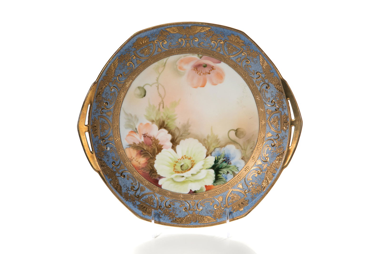 NIPPON TEXAS ROSE PORCELAIN CAKE SERVING PLATE: A two-handled cake serving plate with a central Texas Rose floral scene and a blue and gold Greek key rim. Japanese, green M in wreath, early Noritake. Dia. 28 cm (11 in.)