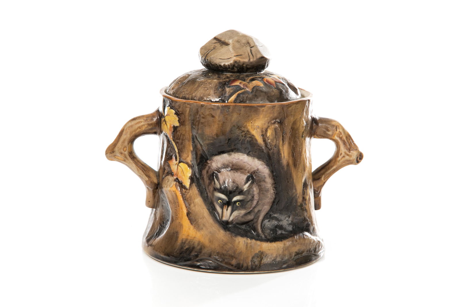 EARLY NORITAKE PORCELAIN MOLDED RACCOON HUMIDOR: Molded as a raccoon emerging from a hole in a tree with naturalistic branch handles and a rock form finial. Japanese, green M in wreath mark, early Noritake. H. 16.5 cm (6 1/2 in.)
