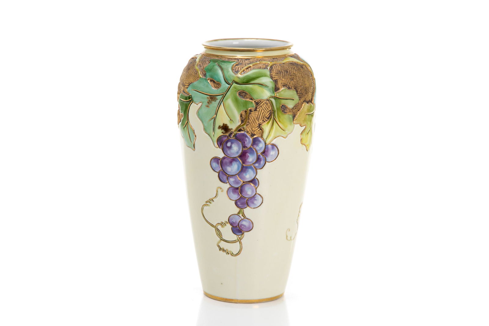 NIPPON AMERICAN INFLUENCED ARTS & CRAFTS VASE: Raised molded in relief grape & vine cluster porcelain vase on a cream ground, basket weave gilded enhancing on the shoulder. Japanese, green M in wreath mark, early Noritake. H. 25.5 cm (10 in.)
