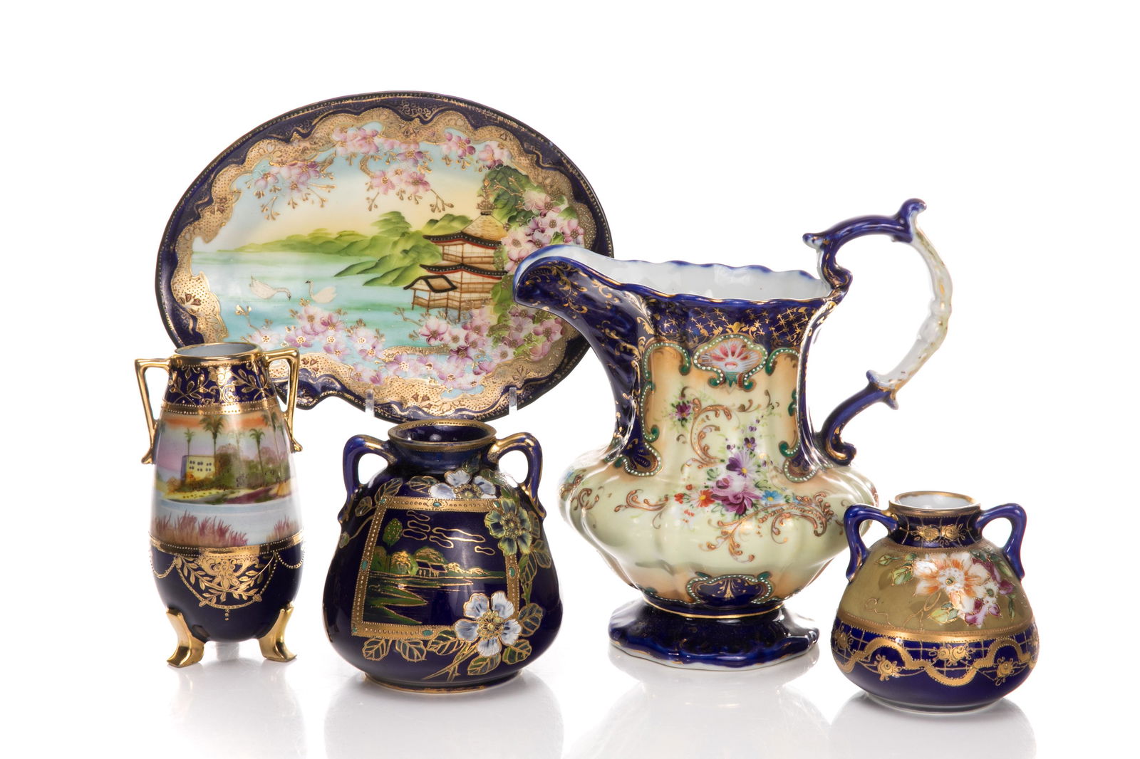 FIVE NIPPON COBALT BLUE PORCELAIN PIECES: Including a pitcher and three different sized two handle vases in glossy cobalt blue and hand painted flowers and decoration. Japanese, one vase with a Green M in wreath mark, early Noritake,two with