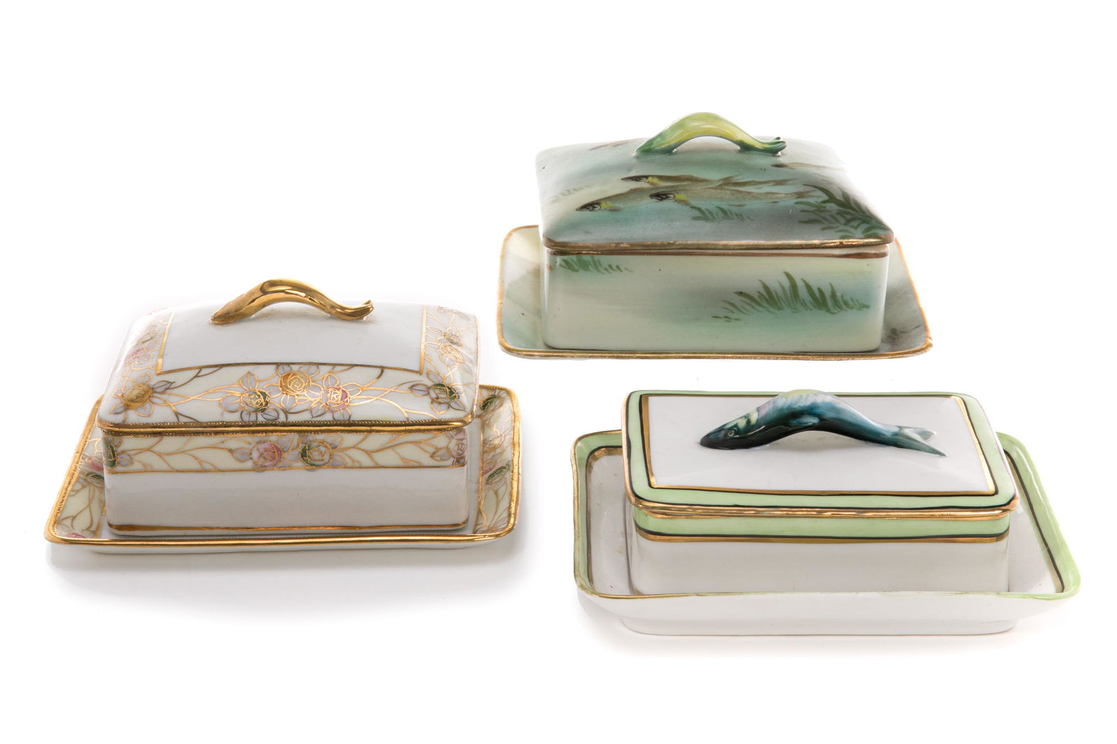 THREE NIPPON PORCELAIN COVERED SARDINE DISHES: Three hand-painted Nippon porcelain covered sardine dishes with figural fish handles. Japanese, two dishes with green M in wreath marks, early Noritake; one with purple M in wreath. H. of tallest: 7.5