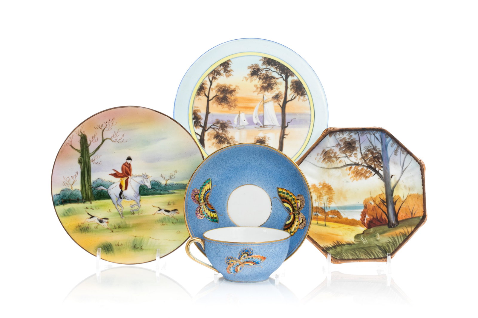 NIPPON PORCELAIN TEACUP SET & THREE TRIVETS: Blue matte glazed ground with hand painted butterflies, gilded rim and handle. Together with three trivets featuring hand painted scenes. Japanese, green Nippon maple leaf mark. H. of teacup set: 6 cm