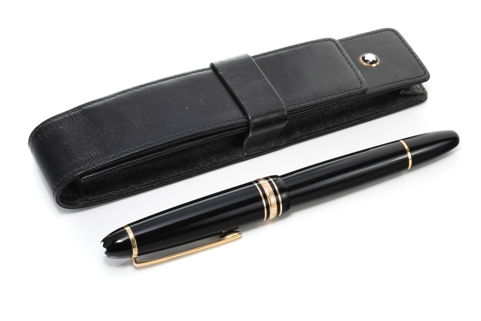MONTBLANC MEISTERSTUCK FOUNTAIN PEN: Classic black resin body with yellow gold plated accents. Twist cap, opens to reveal 14k gold Montblanc fountain pen nib. Piston fill mechanism. Serial no. KK1017021.Together with Montblanc black leat