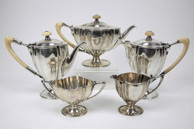 ENGLISH SILVER FIVE PIECE BACHELOR TEA SET: John Round, London, 1905. The plain lobed form is highlighted by the ivory handles and art nouveau mounts. Tea pot L 20 cm (7 7/8 in) approx. 829 g