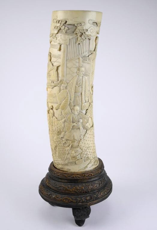 JAPANESE CARVED IVORY TUSK: With fine carved figures in various domestic and festive scenes. Signed. Total height 30 cm (12 1/4"), Height of tusk 21.3 cm (8 1/2")