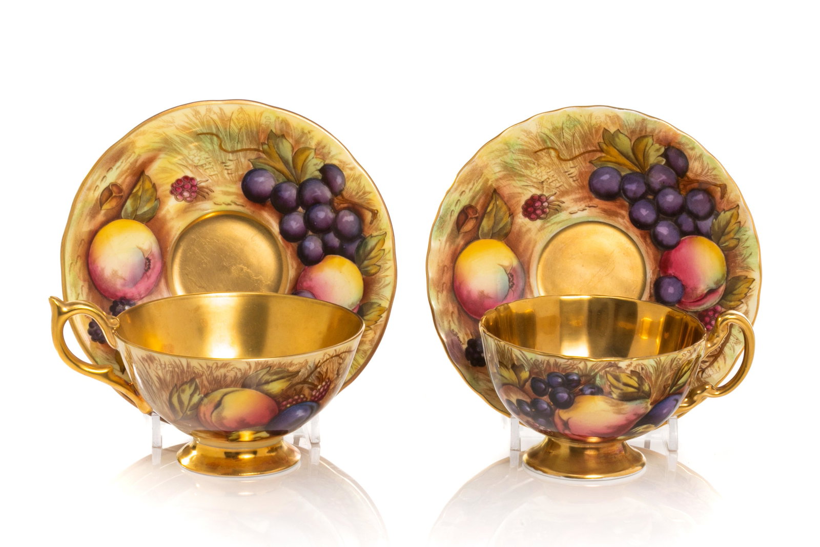 TWO AYNSLEY PORCELAIN FRUIT & GOLD CUPS & SAUCERS: Two Aynsley Orchard Gold hand painted bone china cups and saucers with gold interior and scalloped edge, pattern number C748. Signed D. Jones, with marks for Aynsley to base, circa 1950s. Dia. of sauc