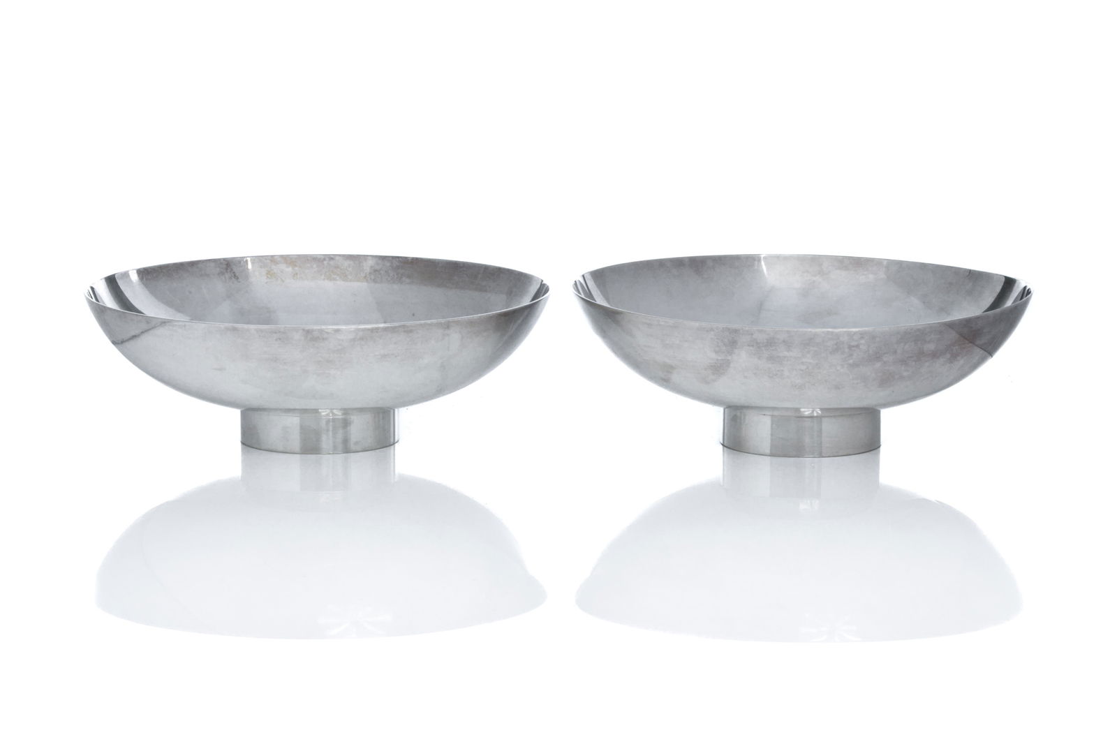 TWO GEORG JENSEN SILVER BOWLS, no. 1133B: Two round silver bowls featuring raised sides with short cylindrical foot. Designed by Soren Georg Jensen. Marked Sterling Denmark, Dessin S.G.J., 1133B Diameter: 14.8cm H. 4.5cm Total weight: 427g