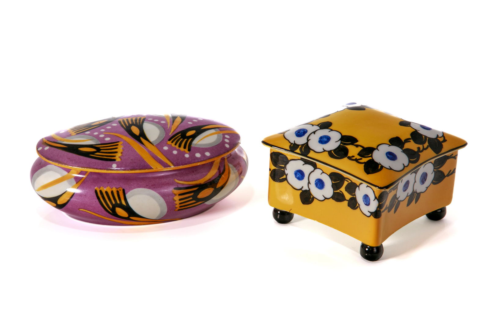 TWO CONTINENTAL ART DECO PORCELAIN BOXES: Two decorative boxes, one oval form Limoges box on purple ground with stylized orange and black sprays. Together with a Suisse Lagenthal yellow porcelain box on bun feet, with blue and whitefloral and