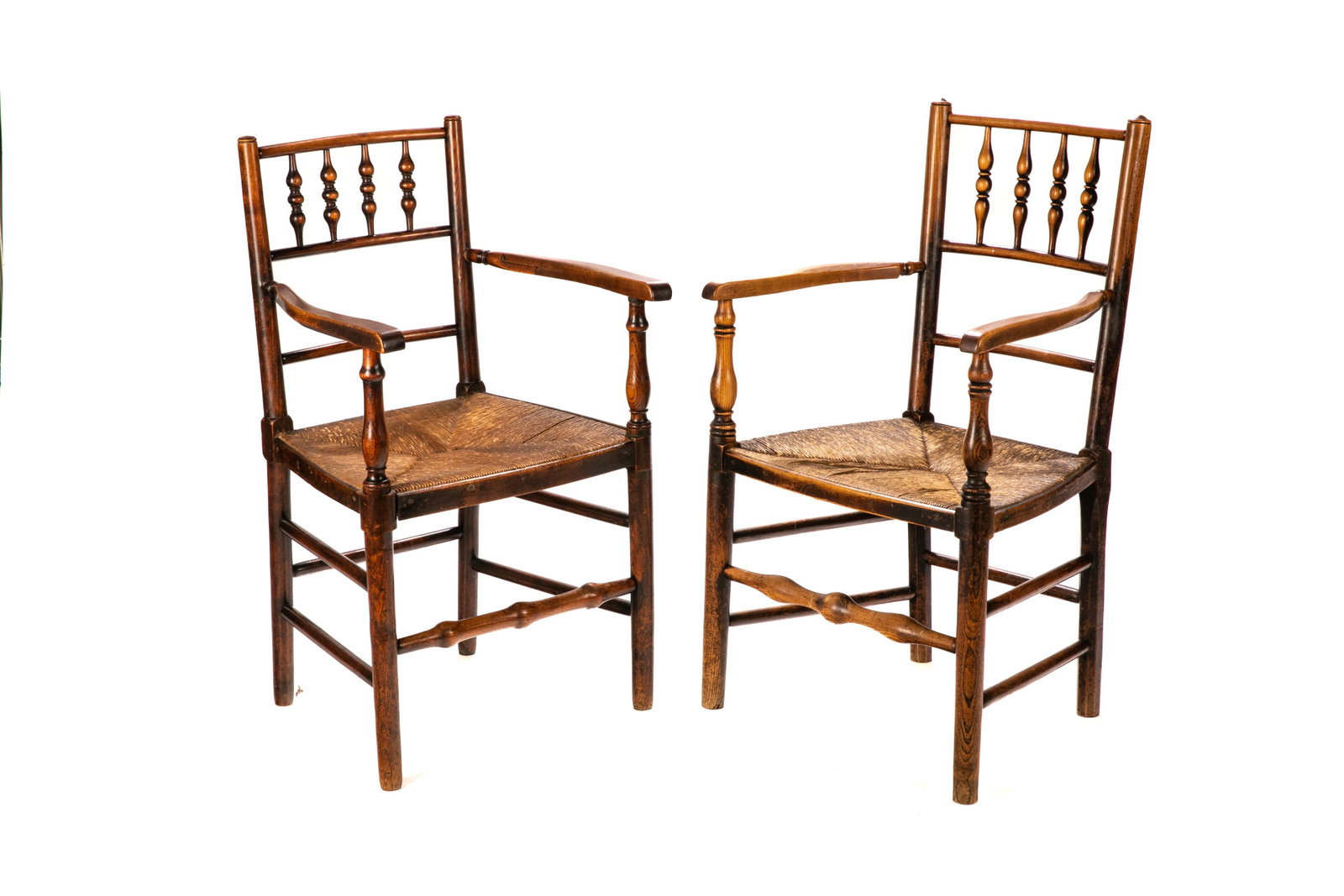PAIR OF LATE GEORGE III ENGLISH COUNTRY ARMCHAIRS: Elmwood frames with bobbin turn stretcher and rushed seats. English, first-half 19th C. H. 36 1/4" W. 21 1/2" D. 20 1/2"